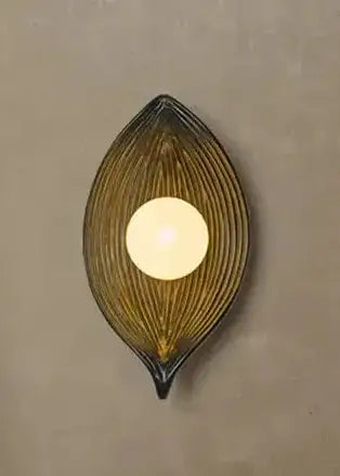 Decorative wall sconce with a leaf-shaped design on a beige wall.