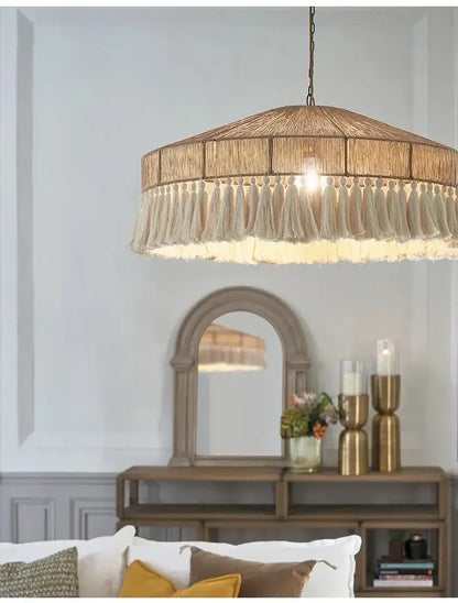 Chandelier hanging above a living room with a mirror and decorative items on a console table Besontique Home