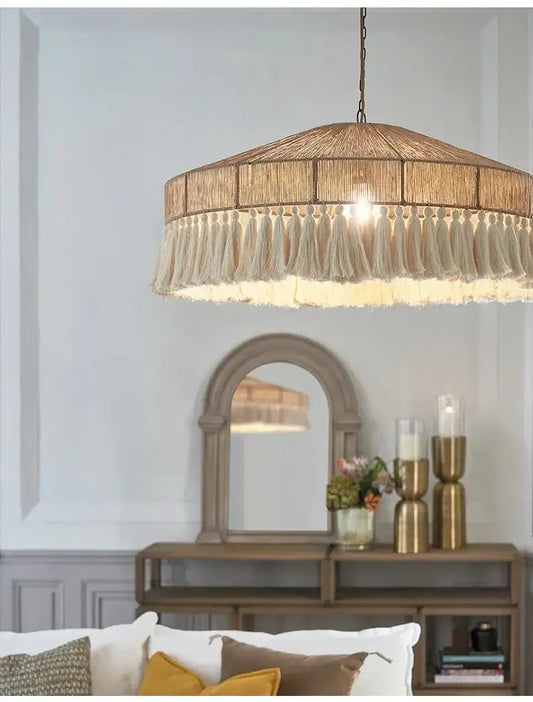 Chandelier hanging above a living room with a mirror and decorative items on a console table Besontique Home