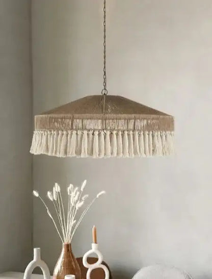 Pendant light with tassels hanging above a dining table with decorative items Besontique Home